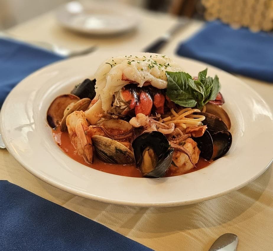 Frutti di Mare — house-made pasta with lobster, shrimp, clams, mussels, and calamari in a spicy tomato broth