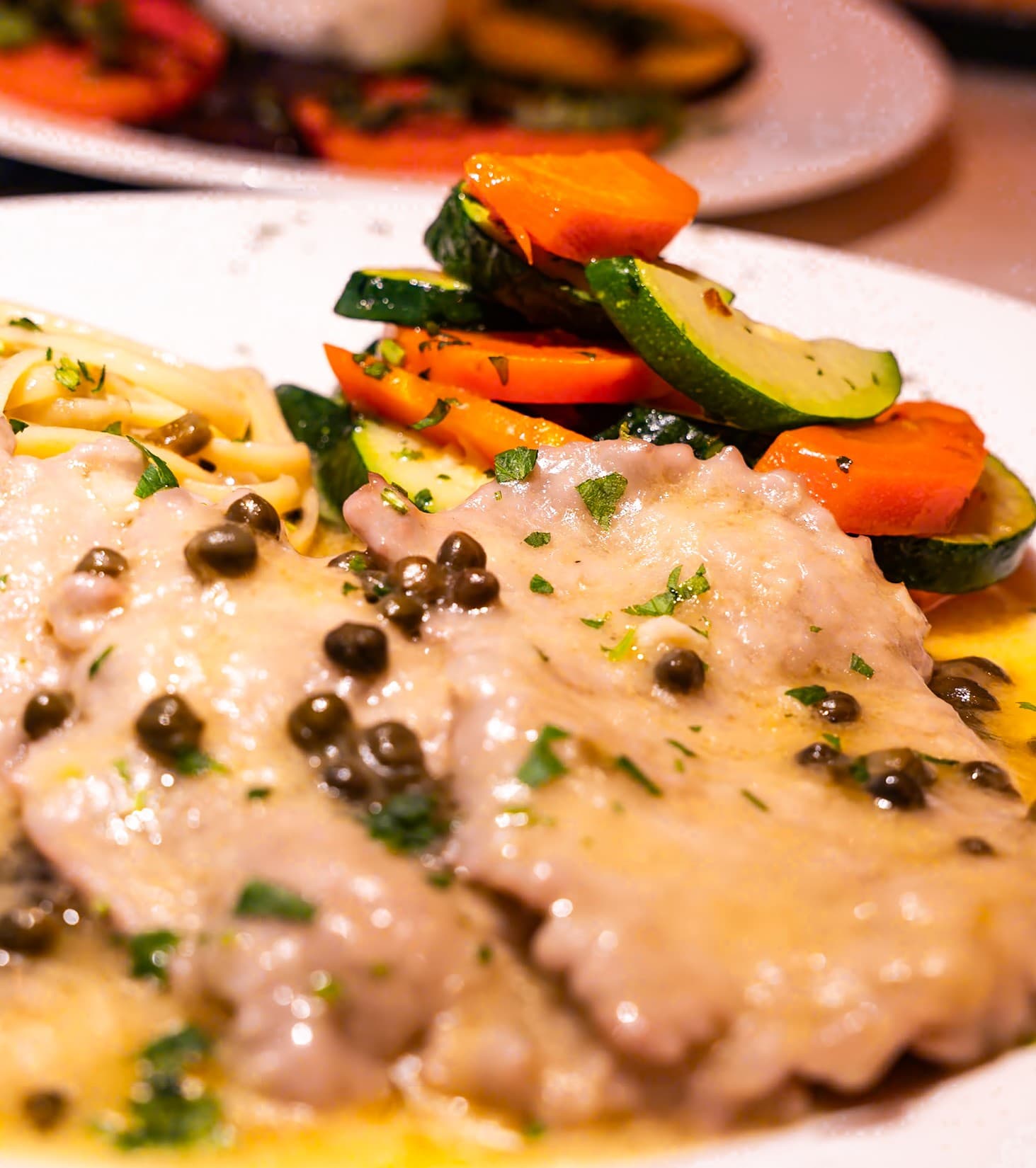 Chicken piccata with capers and white wine lemon sauce, served with linguine and roasted carrots and zucchini