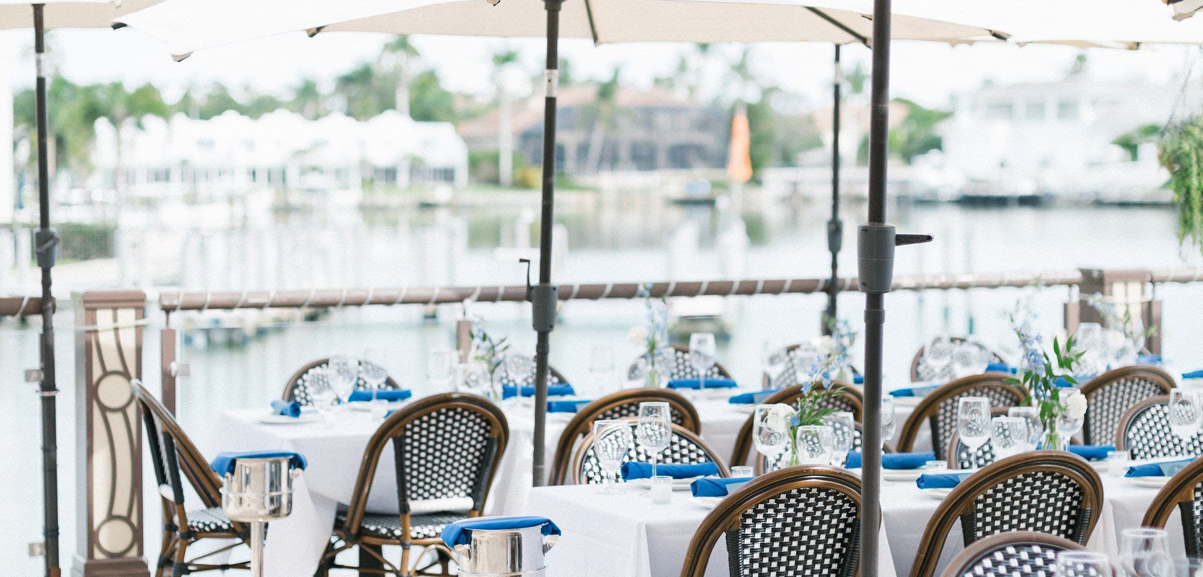 Waterfront terrace at MiraMare Ristorante set for a private event, with white umbrellas and tables overlooking the marina