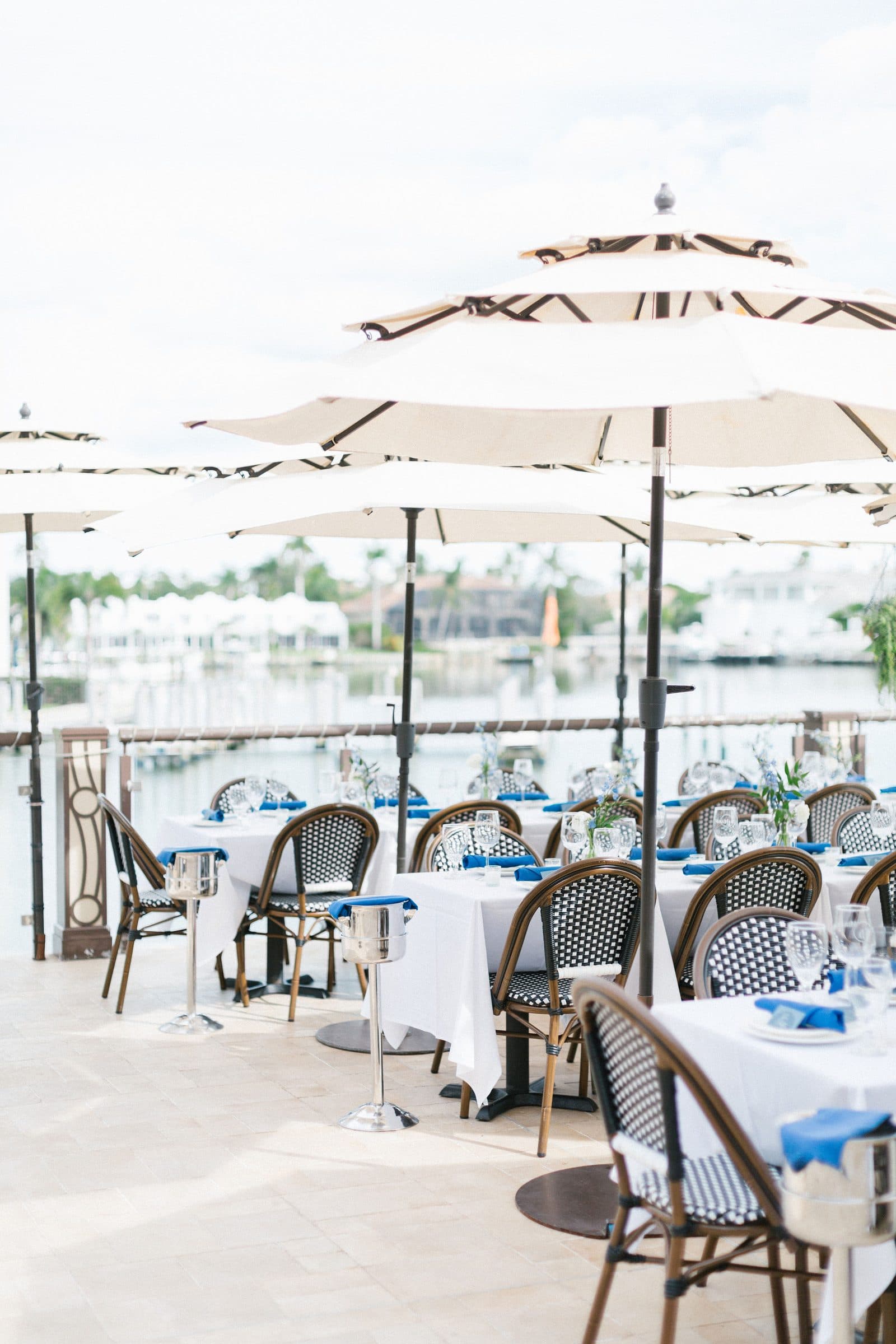 Waterfront terrace at MiraMare Ristorante set for a private event, with white umbrellas and tables overlooking the marina